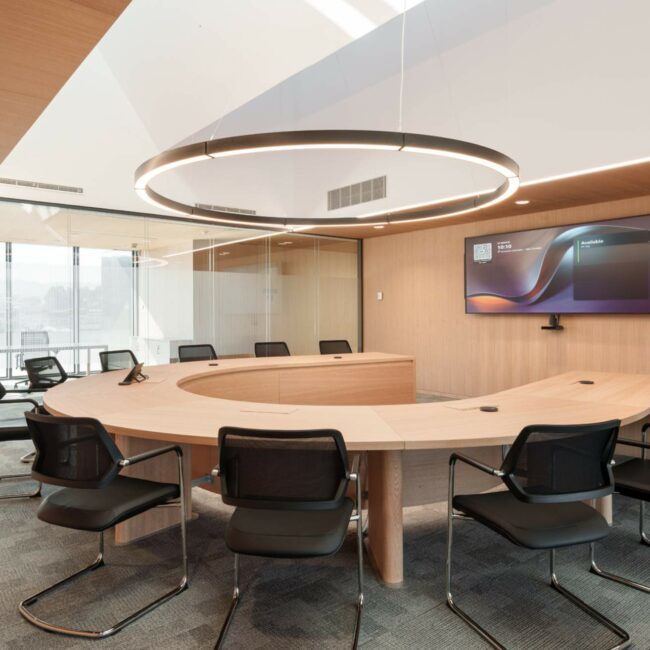 Sala de reuniones con tecnología integrada, pantalla de gran formato y sistema de videoconferencia